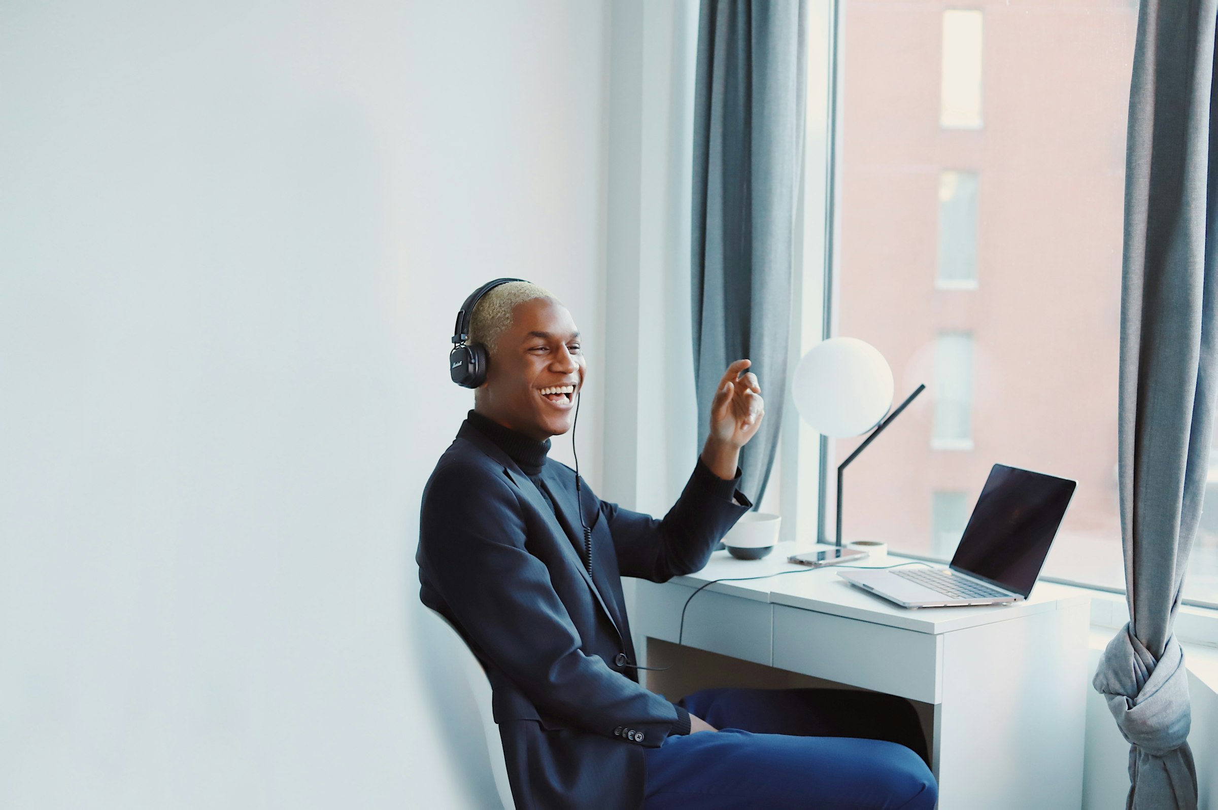 Professional wearing headphones joining an online webinar at his desk